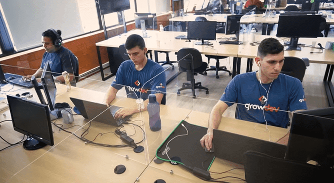 Três pessoas utilizando computadores